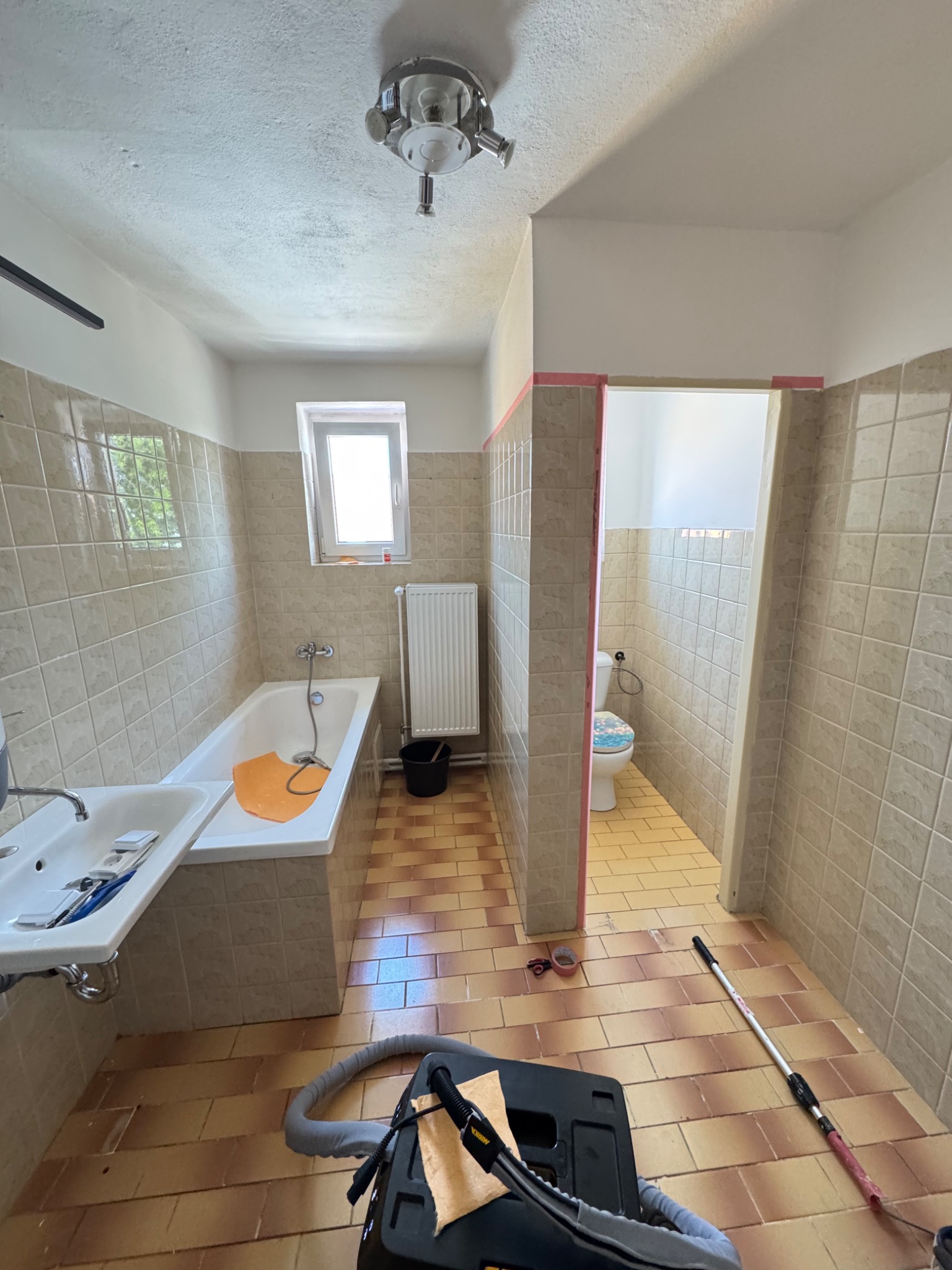 Koupelna s původním keramickým obkladem před realizací